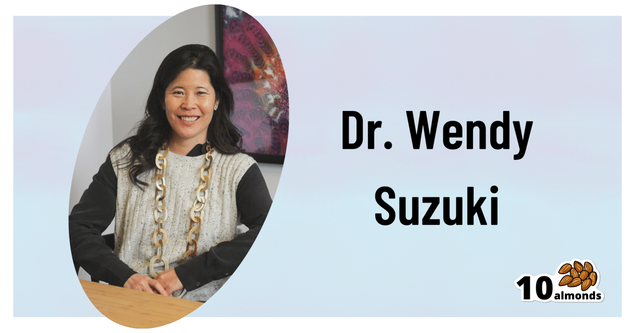 An image featuring Dr. Wendy Suzuki sitting at a desk and smiling. The text beside her reads, "Dr. Wendy Suzuki," with a logo at the bottom right corner displaying "10 almonds" accompanied by an illustration of almonds, emphasizing the connection between nutrition and brain health.